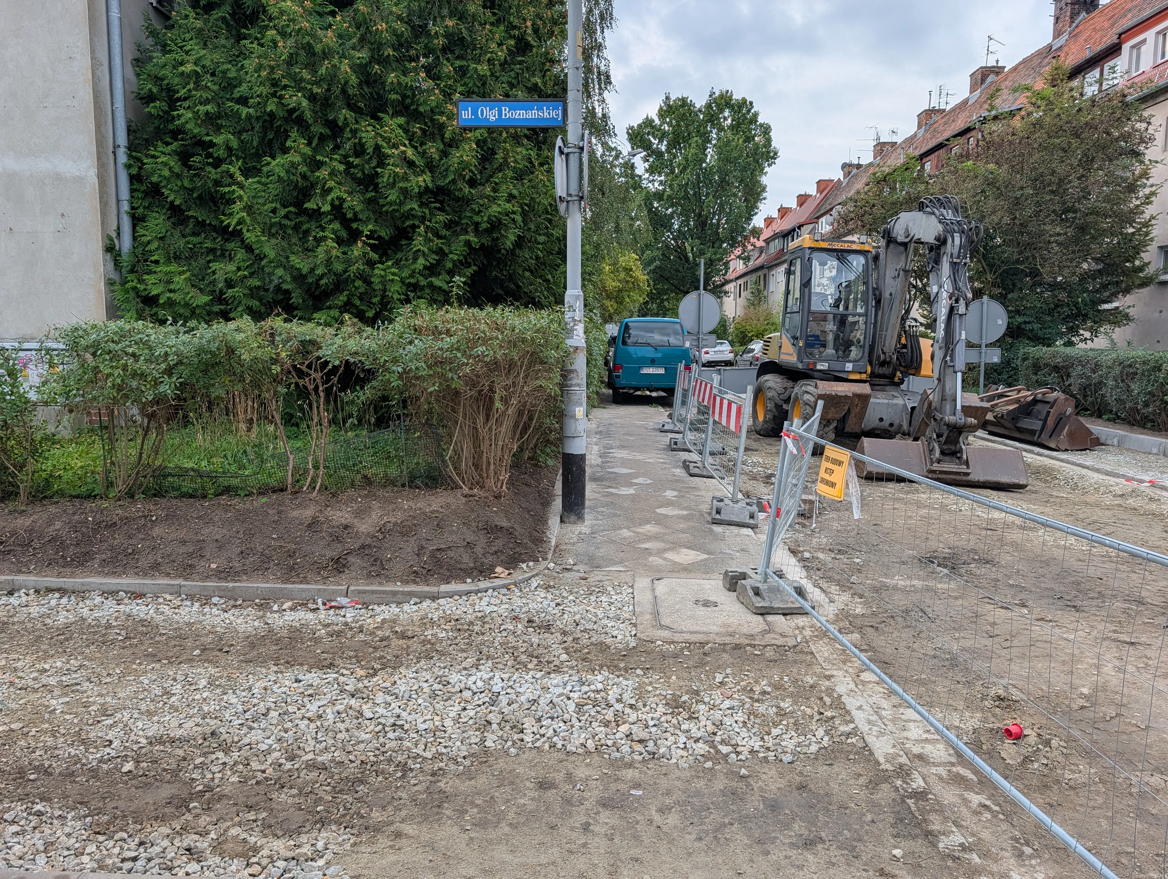 Prace remontowe i koparka przy tabliczce z nazwą ulicy Olgi Boznańskiej na wrocławskim Biskupinie